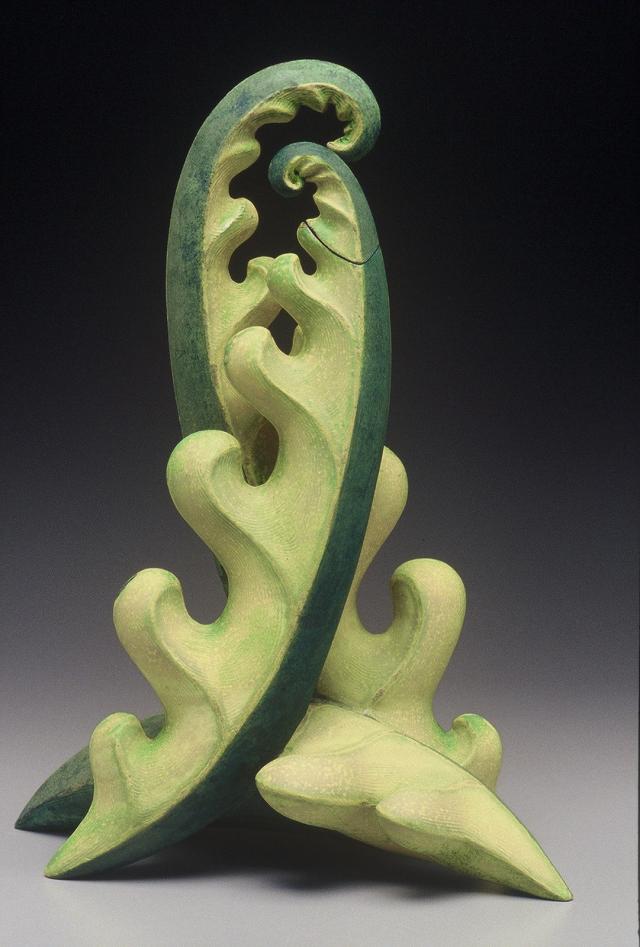 Two green forms that are circular on one side and wavey on the other coming together in an embrace.