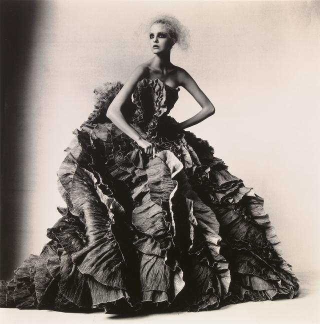 A black and white photograph of a woman in a large dress.