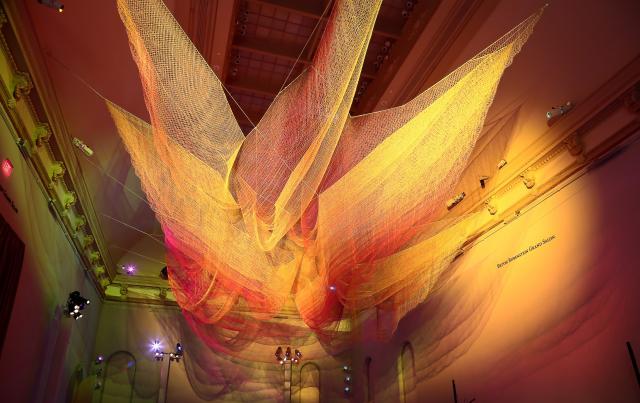 A photograph of colorful mesh hung from the ceiling inside the Grand Salon at the Renwick Gallery.