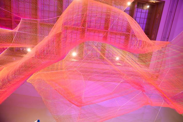 A photograph of colorful mesh hung from the ceiling inside the Grand Salon at the Renwick Gallery.