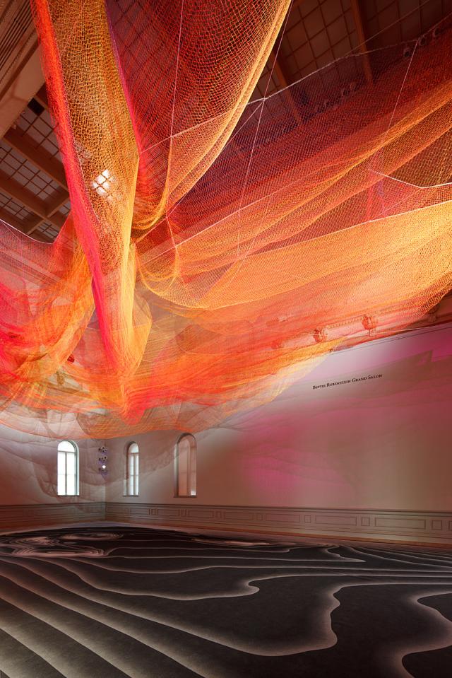 A photograph of colorful mesh hung from the ceiling inside the Grand Salon at the Renwick Gallery.