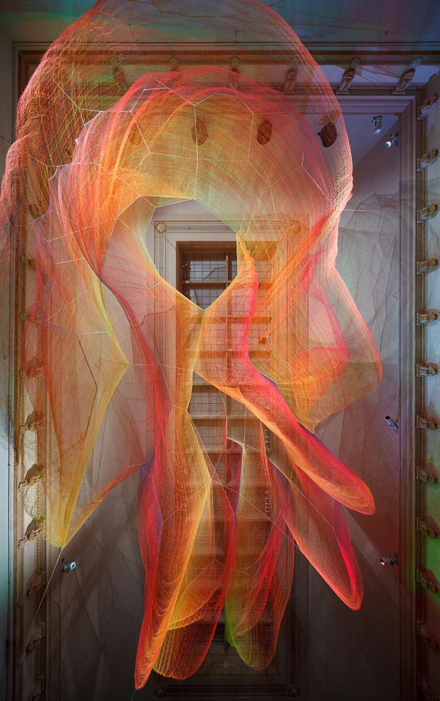 A photograph of colorful mesh hung from the ceiling inside the Grand Salon at the Renwick Gallery.