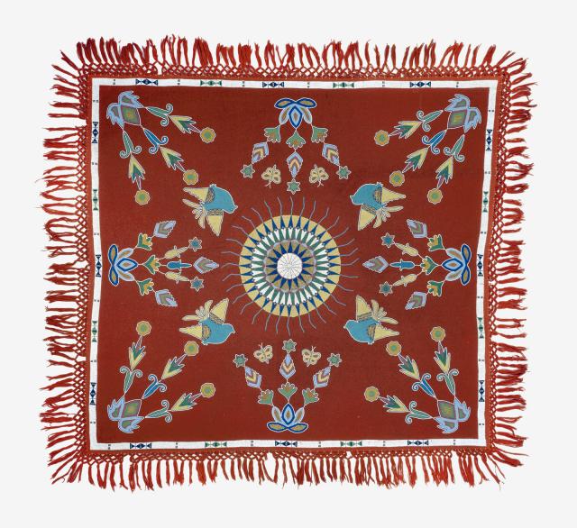 A red tablecloth with a circle in the middle and different designs around it.