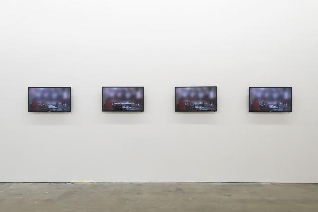 A photograph of four tv screens in an art gallery.