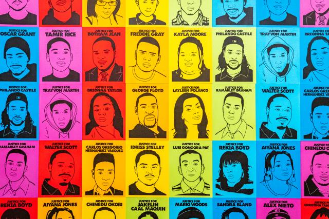 A photograph of an artwork with many different faces. 