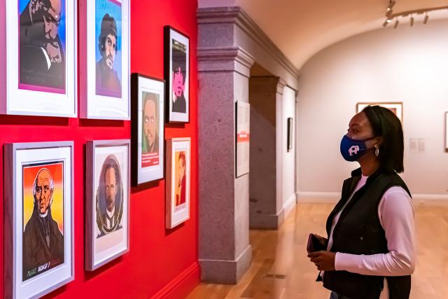 A photograph of a woman looking at artwork