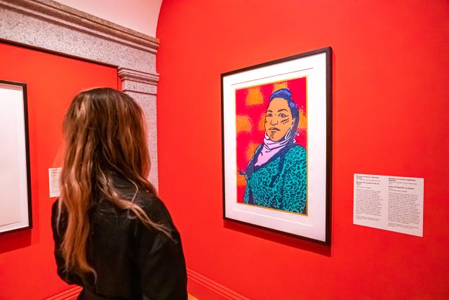 A photograph of a person looking at artwork