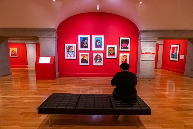A photograph inside an art gallery with a person in the foreground. 