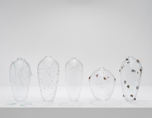 A photograph of five glass objects