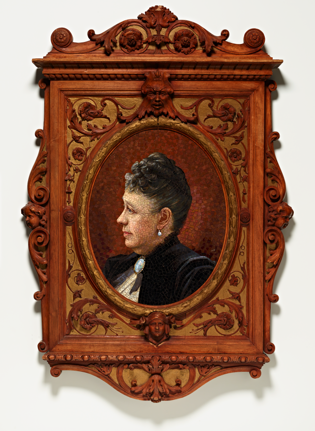 A portrait of a woman in a black dress made from glass mosaic tiles in an ornate wooden frame.