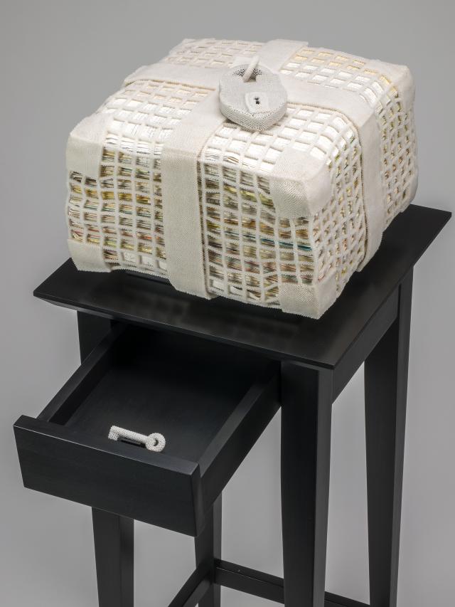 White woven box with letters inside of it