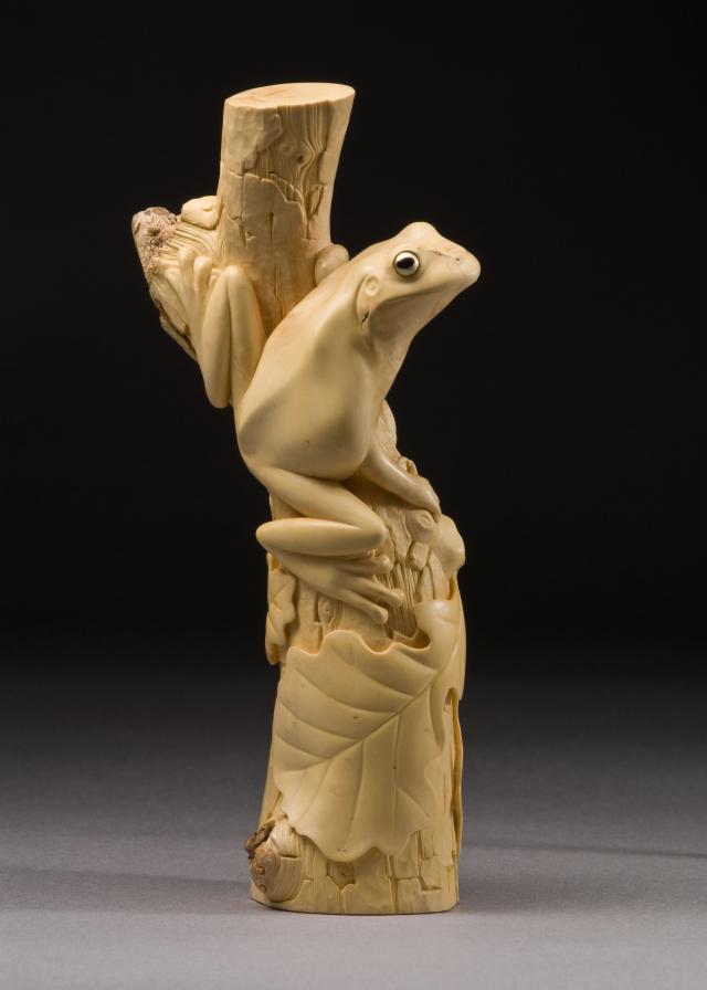 Carving of a frog on a branch