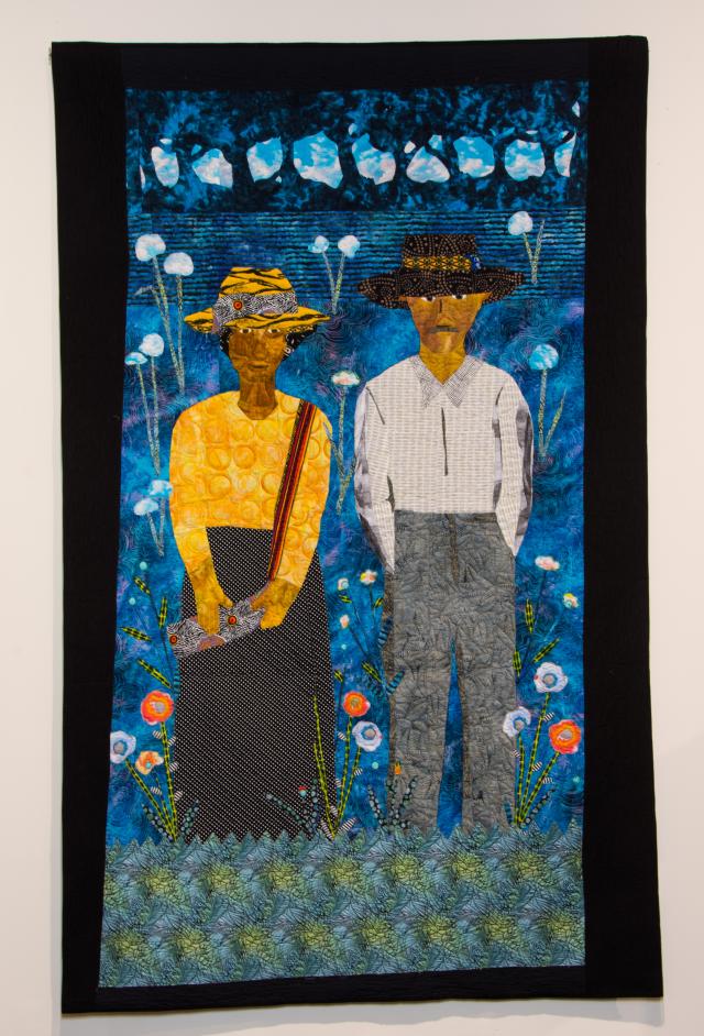 Quilted portrait of two people standing side-by-side.