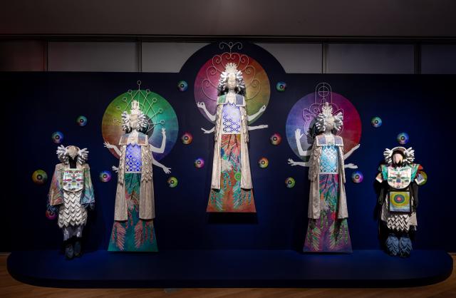 Multimedia art installation with kaleidoscopic projections and mannquins.
