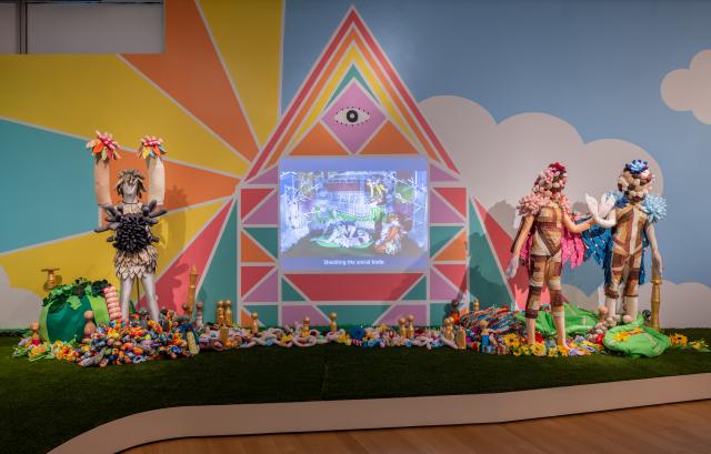 Multimedia art installation with kaleidoscopic projections and mannquins.