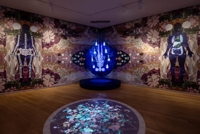 Multimedia art installation with kaleidoscopic projections and mannquins.