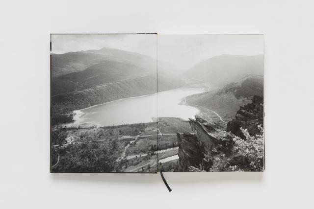 An opened book with a black and white landscape photograph across both pages.