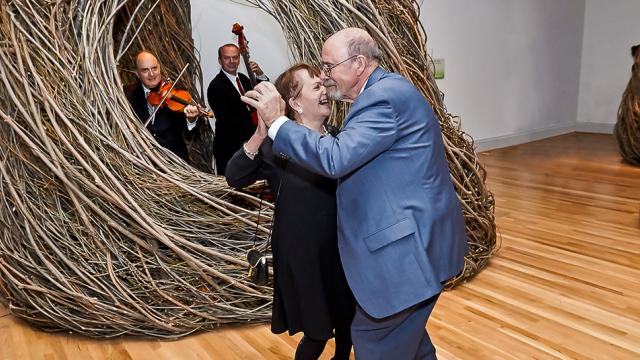 A couple dances while a string band plays music