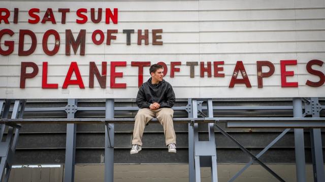 person sitting in front of a theater sign