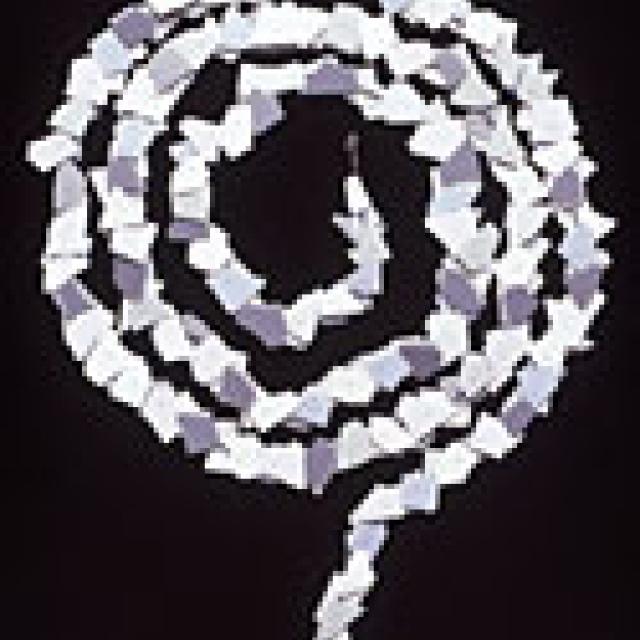 This is a white necklace that is curved in the shape of a snake. 