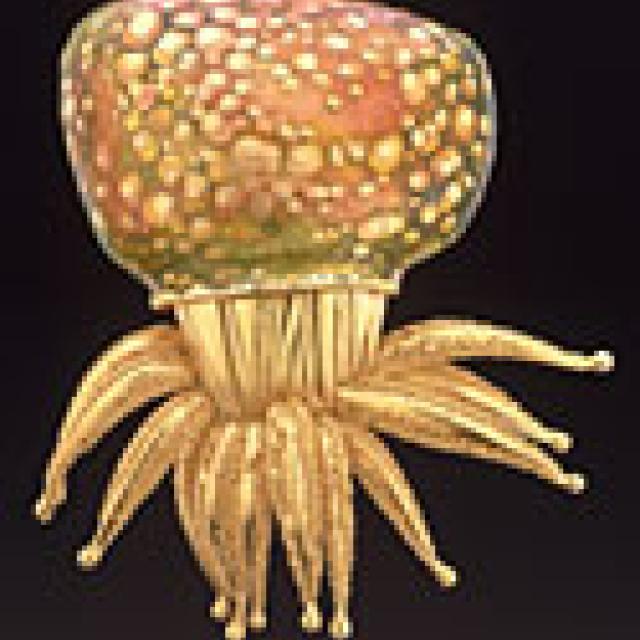 This is a brooch that looks like an orange and yellow octopus. 