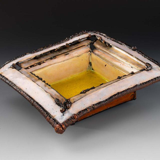 Ceramic square structure with yellow interior base with lighter top and red exterior coloring. 
