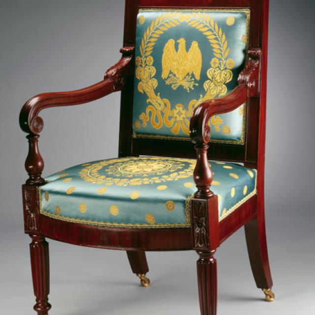 An image of a mahogany armchair with blue and gold upholstery 