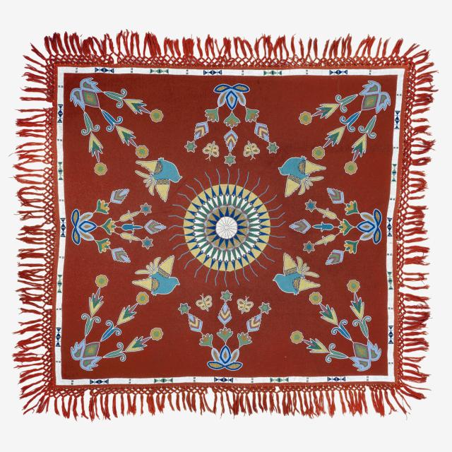 A red tablecloth with a circle in the middle and different designs around it.