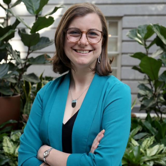A photograph of a woman with short brown hair and glasses.