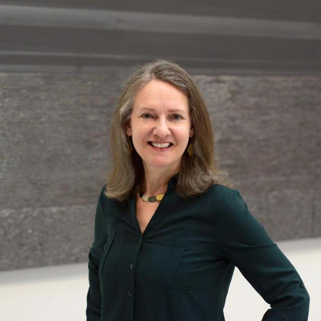 A woman standing in front of an artwork.